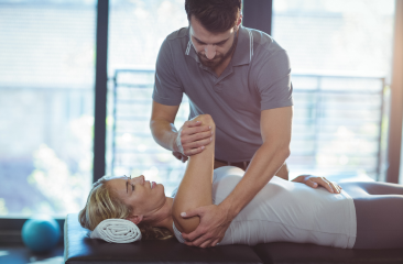 A physiotherapist guiding shoulder exercises or stretches