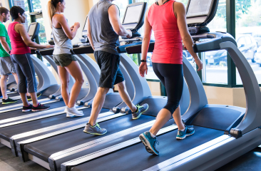 Group of people walking on treadmills